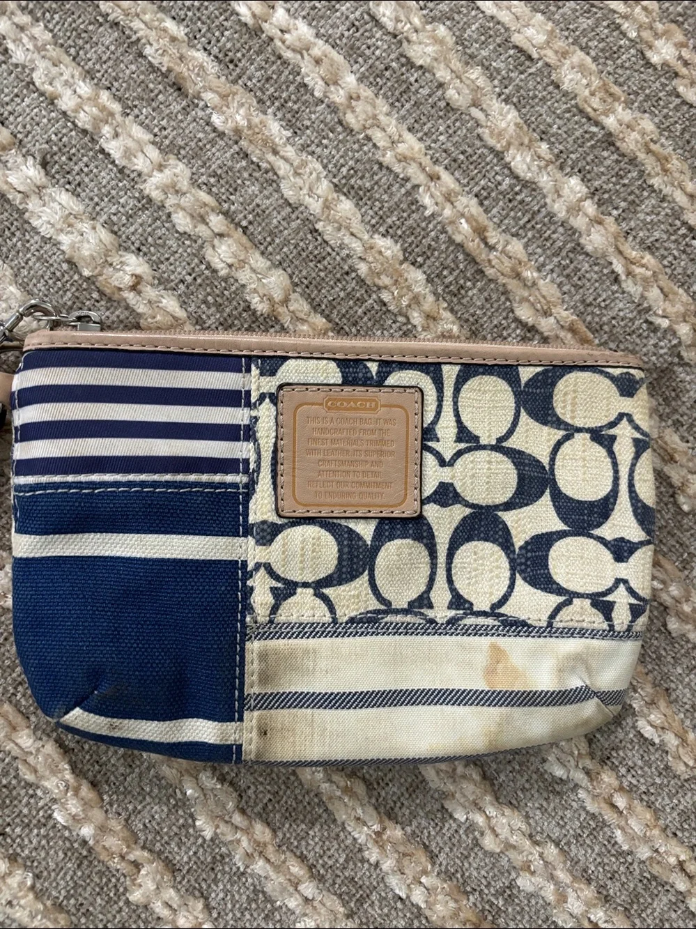 Coach wristlet featuring signature patchwork print in navy and cream